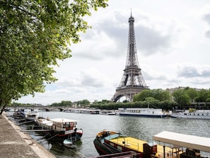 The Eiffel Tower with boats docked along the riverbank. - Ibis Budget Orly Rungis (Rungis)