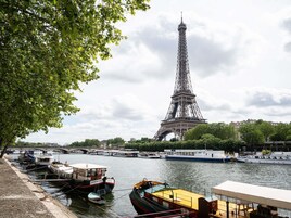 The Eiffel Tower with boats docked along the riverbank.