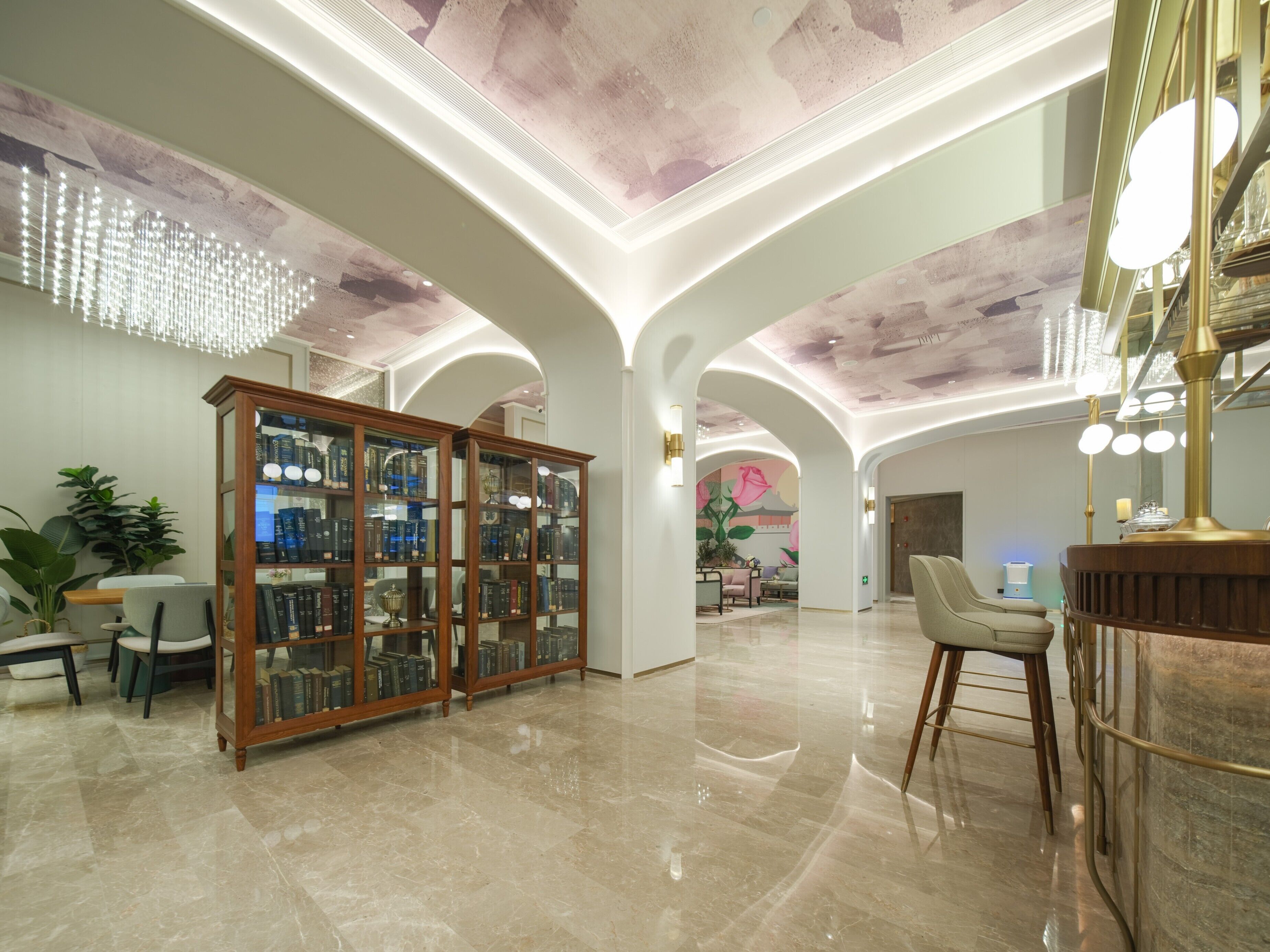 A spacious lobby with a high ceiling, a grand chandelier, and a bar area.