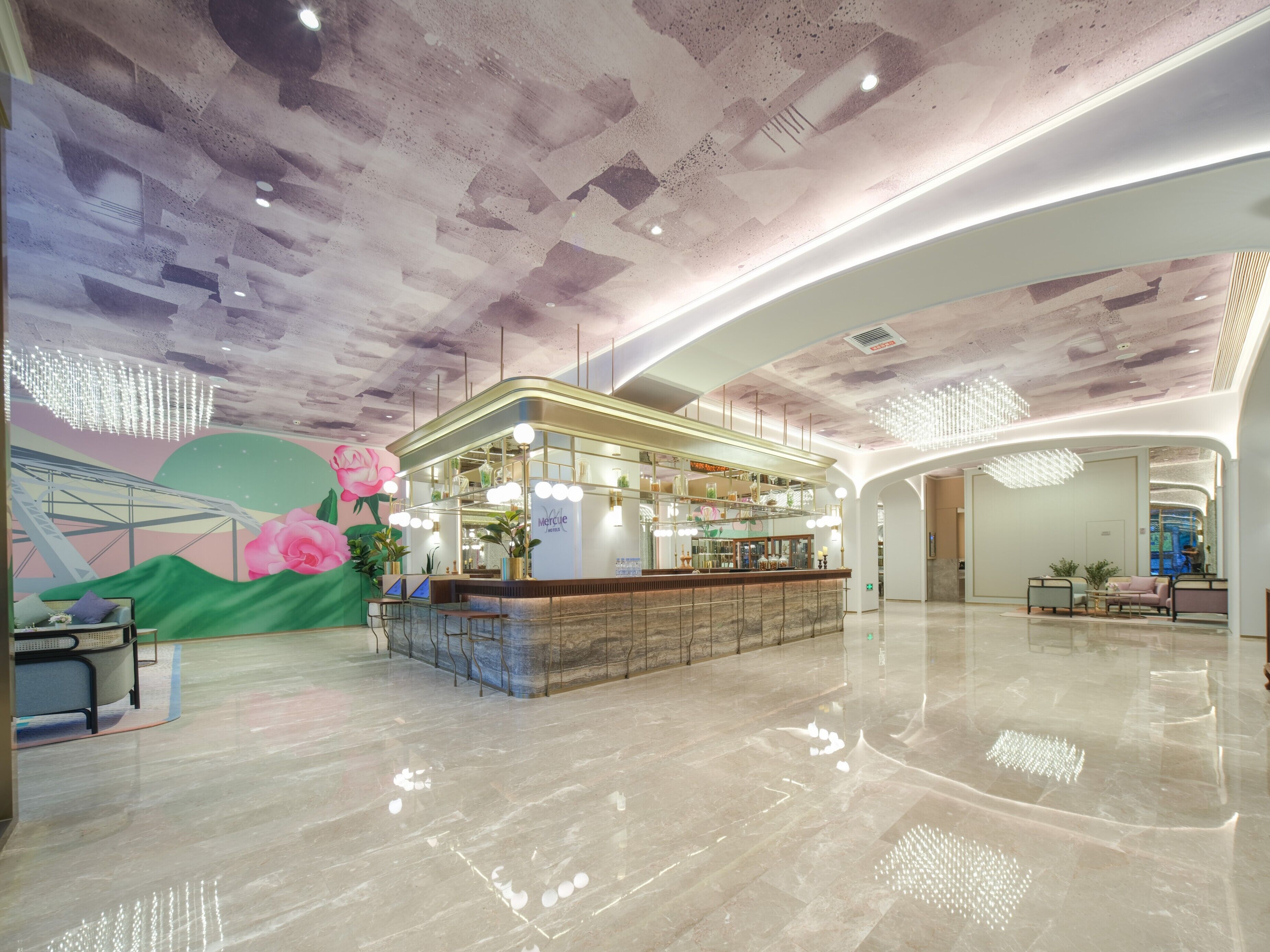 A modern lobby with a reception desk, seating area, and a mural.