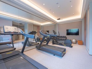 A modern gym with treadmills, a rowing machine, and a TV screen. - Mercure Lanzhou University Tianshui (Lanzhou)