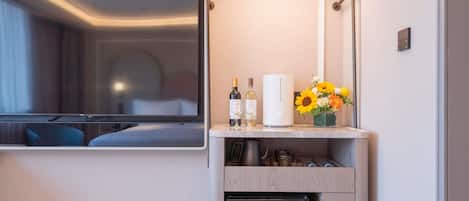 A hotel room with a bed, a TV, a minibar, a refrigerator, and a window.