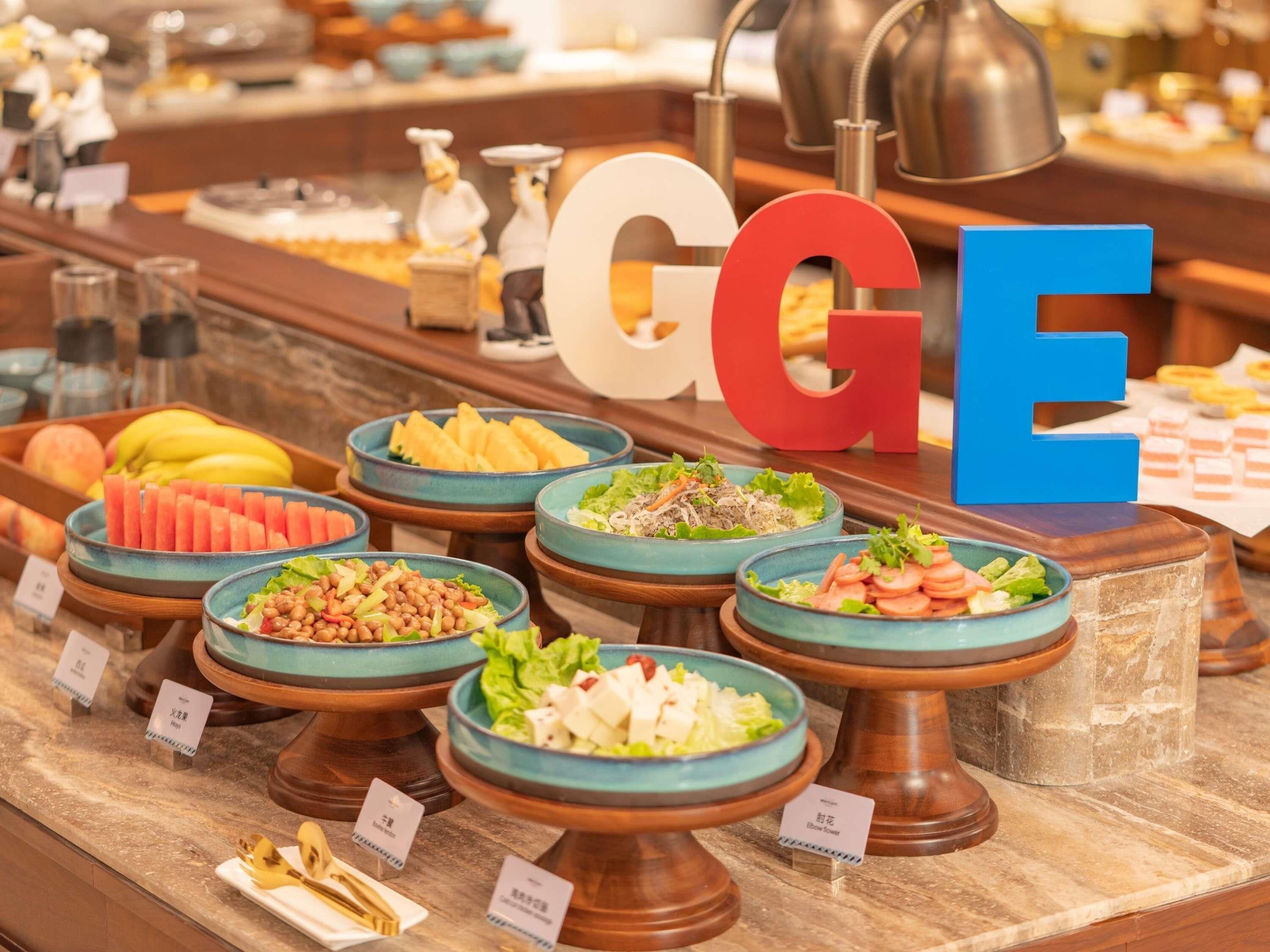 A buffet with various food items and a large 'GGE' sign.