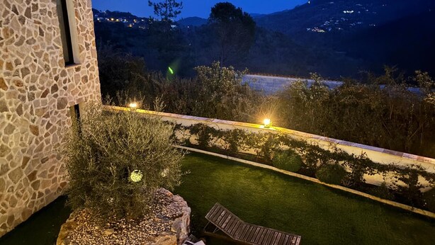 Un edificio de piedra con vista a un paisaje montañoso al anochecer.