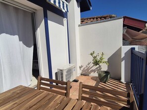 A wooden deck with a bench, a potted plant, and an air conditioning unit. - House in Sokoa – 5 minutes from St. Jean de Luz Bay   (Urrugne)