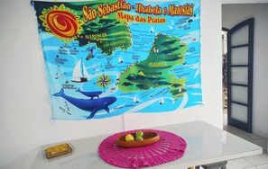 Eine farbenfrohe Karte von São Sebastião, Ilhabela und Maresias an einer Wand.