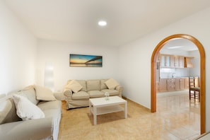 Una sala de estar con un sofá, una mesa de centro y un cuadro en la pared.