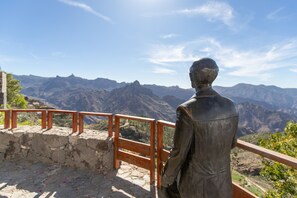 A statue of a man overlooking a mountainous landscape. - Casa Ñico: Vacation Home with Mountain Views and Wi-Fi (Artenara)