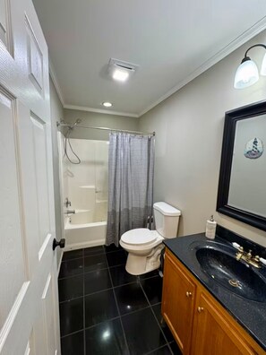 Un baño con bañera, inodoro y lavamanos.