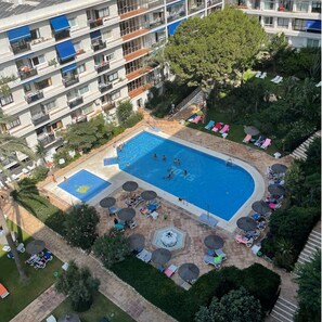 A multi-story hotel with a swimming pool, sun loungers, and a garden area. - 1.Skol Marbella 703A (Marbella)