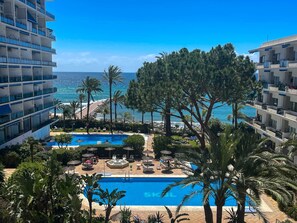 A resort with a pool, palm trees, and a view of the ocean. - 2. Skol Marbella 337B (Marbella)