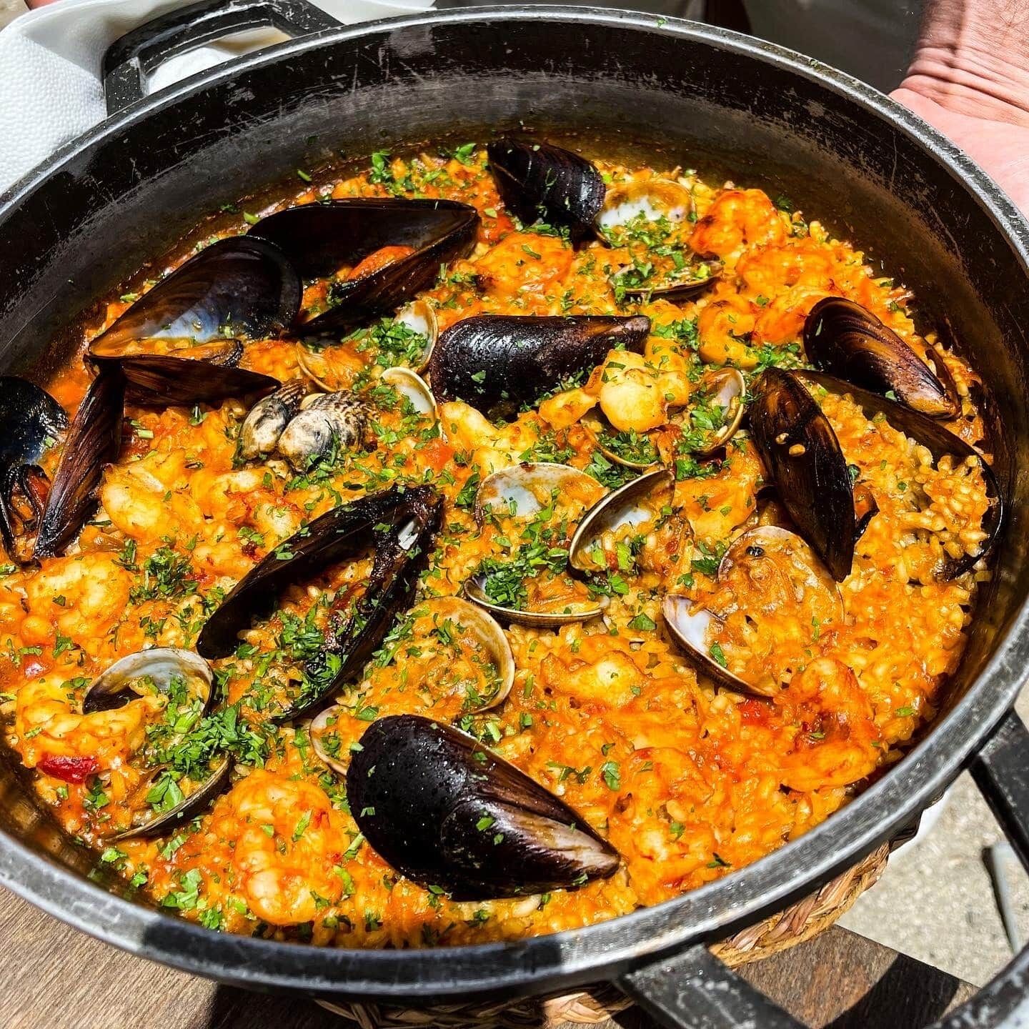 Une grande marmite remplie de paella aux fruits de mer.