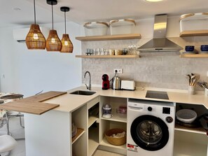Eine moderne Küche mit Einbauwaschmaschine, Spüle und Toaster.