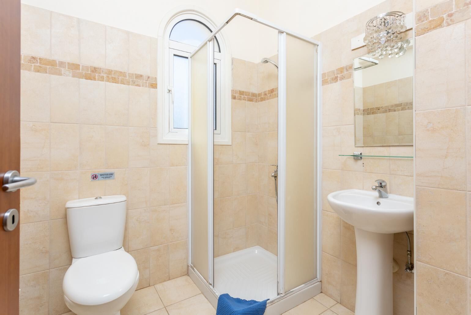 A bathroom with a toilet, a shower enclosure, and a sink.