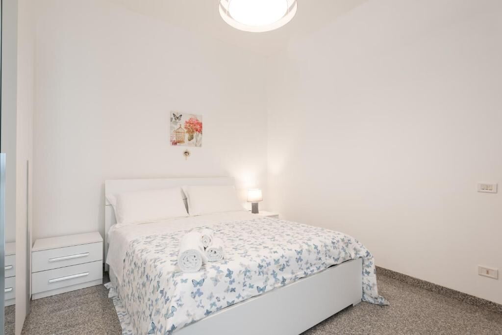 Une chambre à coucher avec un lit, une table de chevet et un tableau accroché au mur.