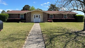 A two-story house with a front porch, a driveway, and a well-maintained lawn. - Restful ranch, 4.6 miles from The Masters. 3-bedroom house, 2 full baths (Martinez)