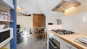 Une cuisine compacte équipée d’un four à micro-ondes, d’une cuisinière et d’un coin repas avec des chaises et une table.