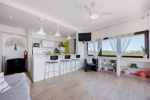 Ein modernes Apartment mit Küche, Essbereich und Wohnzimmer.