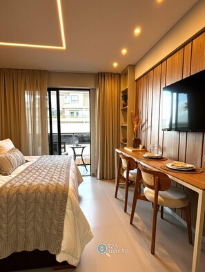 Ein Hotelzimmer mit Bett, Schreibtisch, Stuhl, Fernseher und einem Balkon mit Vorhängen.