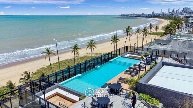 A rooftop pool with a view of the beach and city skyline. - Beach Haus by 123Quarto (João Pessoa)