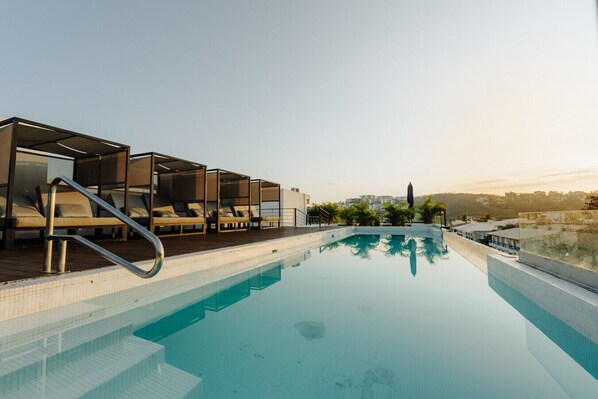 A rooftop swimming pool with lounge chairs and a clear view of the cityscape. - Modern Top Floor Studio/Santa Cruz/Min`s to Beach (Crucecita)