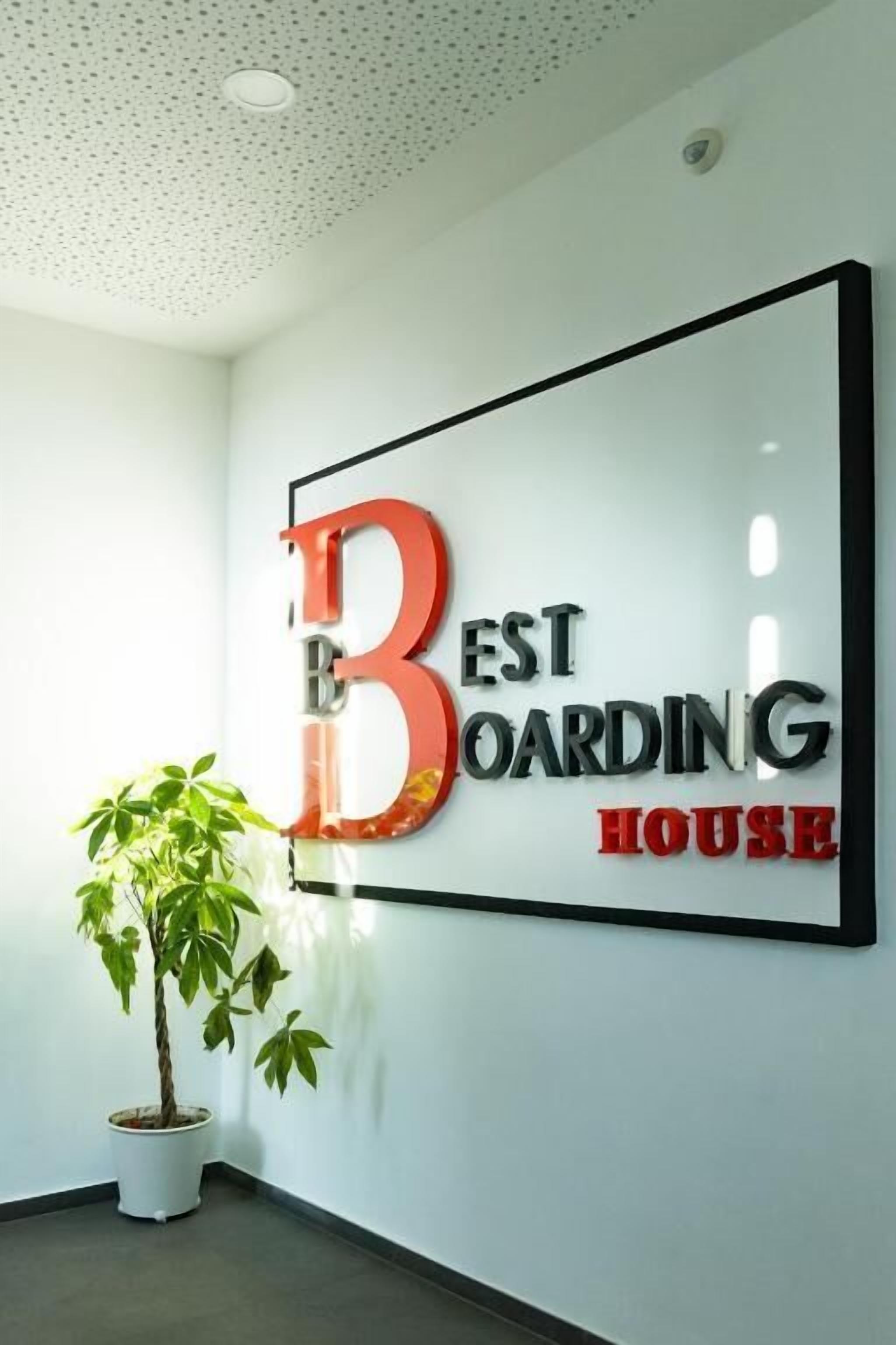 A wall with a sign that reads 'BEST BOARDING HOUSE.'