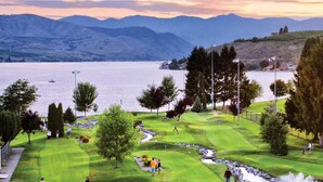 A golf course with a lake and mountains in the background. - Views+Pool+Hot tub: Summer Lake Days Made Easy at WorldMark Chelan – Lake House (Chelan)