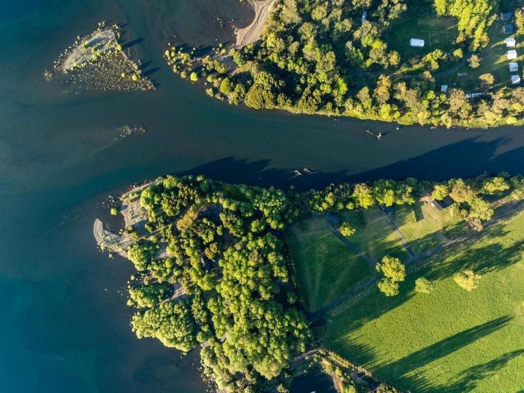 An aerial view of a coastal area with multiple islands, clear water, and green vegetation.