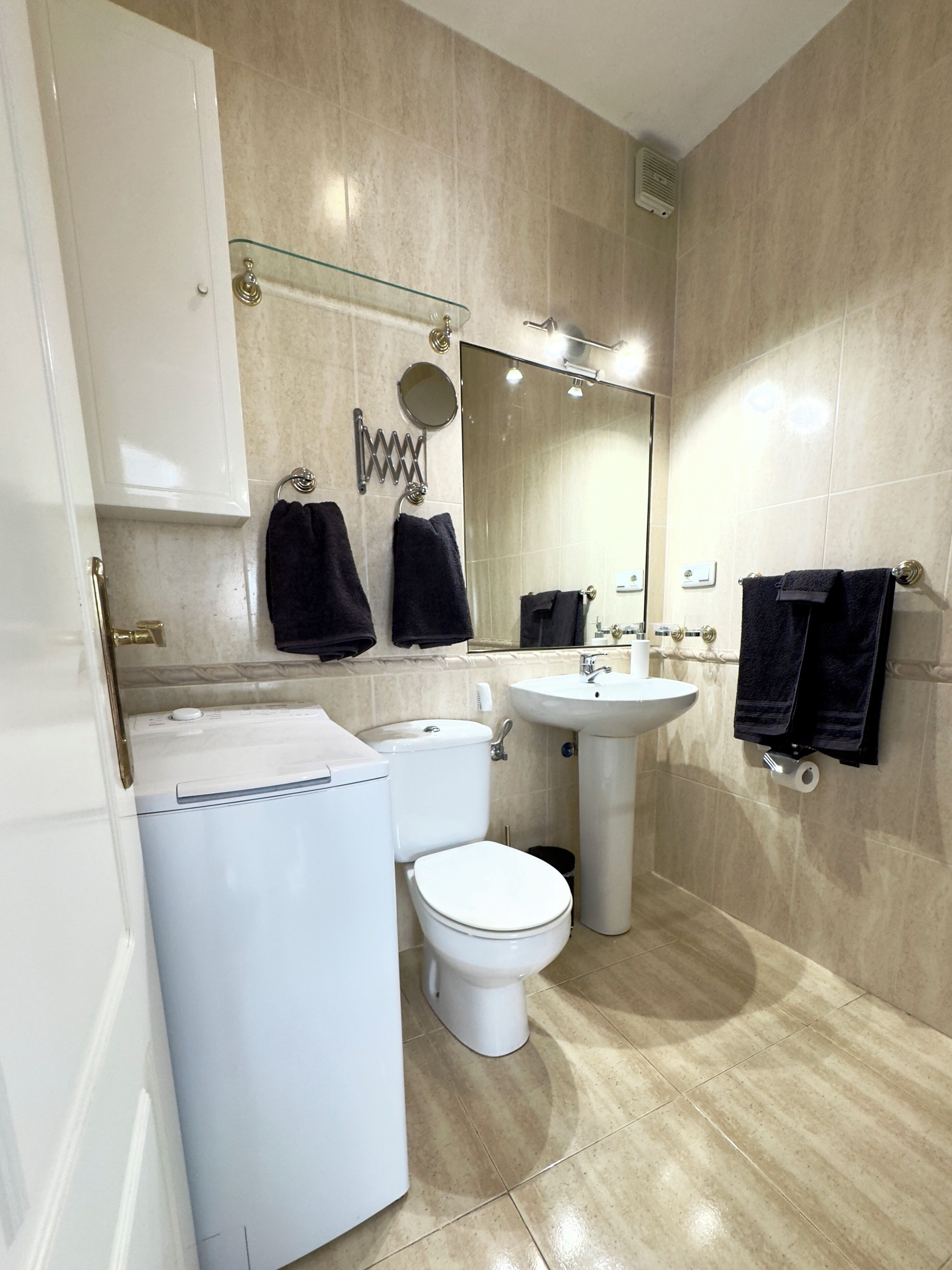 A modern bathroom with a toilet, sink, and glass shower enclosure.