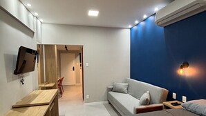 Een moderne slaapkamer met een bed, bureau en een bank.