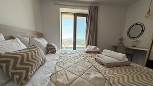 Habitación de hotel con cama, escritorio, silla y vistas al exterior.