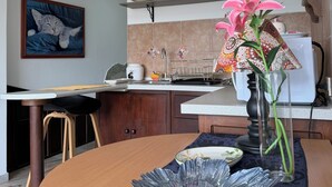 Eine moderne Küche mit Essbereich, einer Uhr und einer Blumenvase.