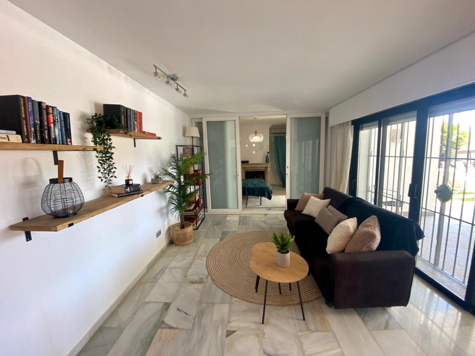 A modern living room with a sofa, a coffee table, and bookshelves.