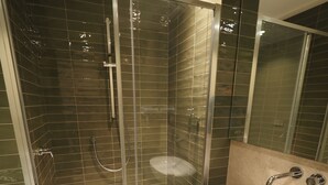 A modern bathroom with a glass-enclosed shower, a white sink, and a large mirror. - L' Angolo sul Mare (Naples)