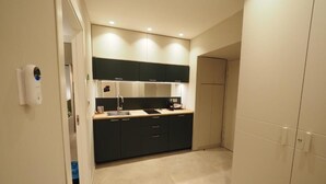 A compact kitchen with dark cabinets, a countertop, and a built-in oven. - L' Angolo sul Mare (Naples)
