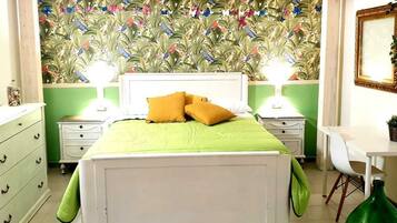Un dormitorio con una cama, dos mesitas de noche, un aparador, un escritorio y una silla.