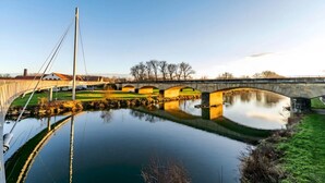 Un puente sobre un río tranquilo con cielo despejado.