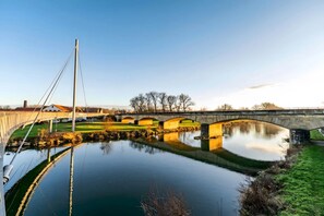 Un pont enjambant une rivière paisible, sous un ciel dégagé.