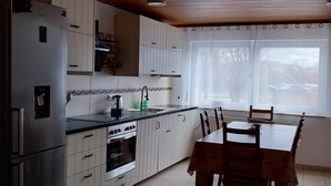 Une cuisine équipée d’un réfrigérateur, d’une cuisinière et d’une table à manger.