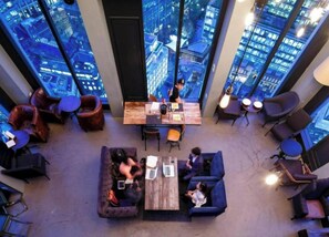 A modern lounge with a city view, comfortable seating, and a central table. - Student  Modern Studio at Spitalfields (London)