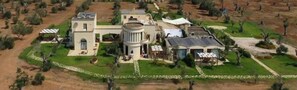 A large estate with multiple buildings, a central circular structure, and a well-maintained lawn. - Room 'Residenze Uliveto - Residence 14, private terrace and air conditioning (Nardò)