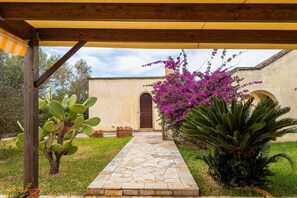A stone pathway leading to a building with a wooden pergola overhead. - Room 'Residenze Uliveto - Residence 7, private terrace and air conditioning (Nardò)