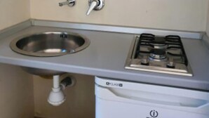 A kitchen with a stainless steel sink, a gas stove, and a built-in dishwasher. - Apartment 'Residenze Uliveto - Residenza 10' Private Terrace and Air Conditioning (Nardò)