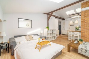 Une chambre à coucher avec un lit, une table de chevet, une lampe et un plateau avec des verres et une bouteille.