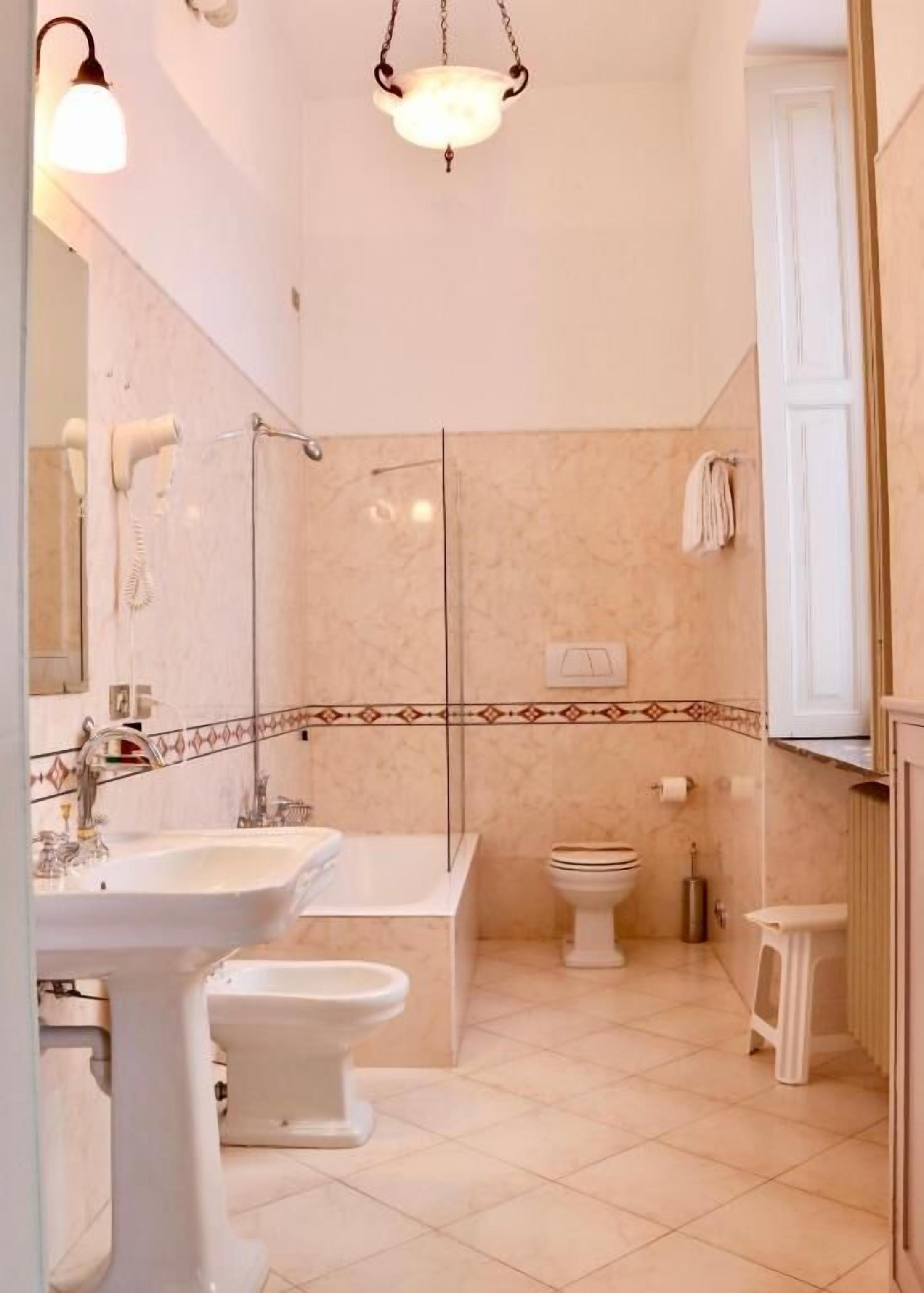 Un baño con lavamanos, bañera, inodoro y zona de ducha.