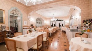 A long dining hall with multiple tables and chairs, arched ceilings, and chandeliers. - Hotel du Parc (Stresa)