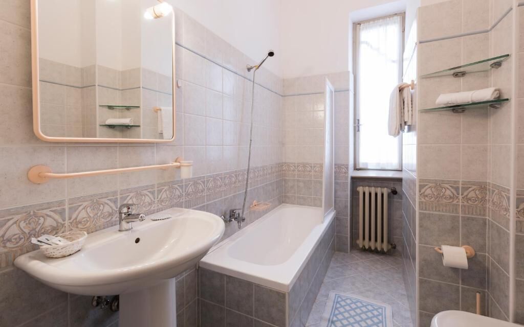 A bathroom with a sink, bathtub, shower, and toilet.