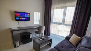 A modern living room with a flat-screen TV, a sofa, a coffee table, and a small side table. - ELEA PREMİUM STAY Zentrale Standard-Doppel-Suite (PAMUKKALE)
