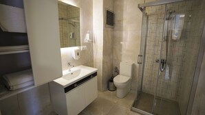 A modern bathroom with a glass-enclosed shower, a white sink, and a toilet. - ELEA PREMİUM STAY Zentrale Standard-Doppel-Suite (PAMUKKALE)