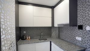 A kitchen with a granite countertop, a sink, and white cabinets. - ELEA PREMİUM STAY Zentrale Standard-Doppel-Suite (PAMUKKALE)